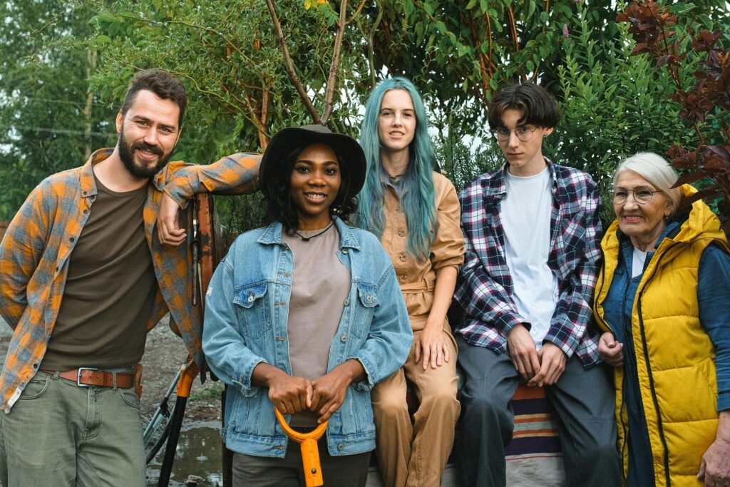 Diverse group of friends enjoying togetherness in an outdoor farm setting, showcasing unity and diversity.